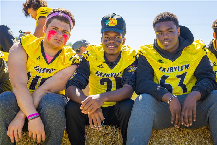 Three football players smile
